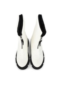 Witte gequiltte laarzen met zwarte zolen, voorzien van zijritsen en een zachte binnenvoering. Rond gevormde neus, duurzame hardware accenten.