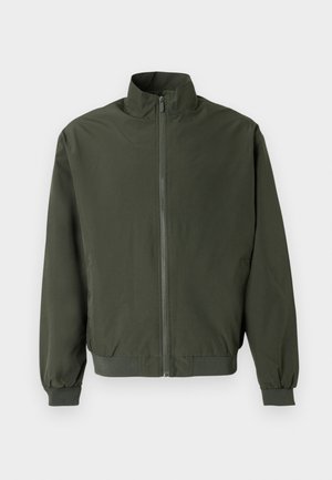 Prosta ciemnozielona kurtka na zamek z wysokim kołnierzem, elastycznymi mankietami i ściągaczem u dołu, pokazana na białym tle.