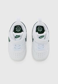 Λευκά Nike sneakers με πράσινες λεπτομέρειες, διαθέτουν ιμάντα Velcro, κορδόνια, περφορίσεις στη μύτη και επενδεδυμένο κολάρο για άνεση.