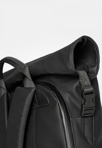 Schwarzer Rolltop-Rucksack aus strukturiertem Stoff. Verfügt über einen stabilen Schnallenverschluss sowie gepolsterte Schultergurte für Komfort und Unterstützung.