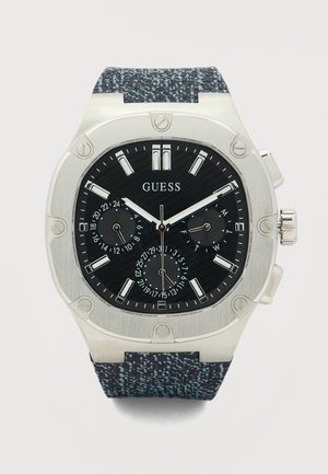 Meeste Guess käekell musta sihverplaadiga, hõbedaste markeritega, kolme alamsihvriga, hõbedase raamiga, millel kruvid, ning tekstuuriga tumesinise rihmaga.