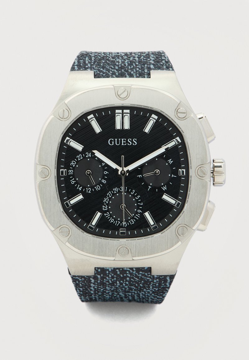 Men's Guess wristwatch with black dial, silver markers, three subdials, silver bezel with screws, and textured dark blue strap.