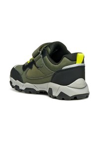 Chaussure de randonnée verte et noire avec une tige en tissu texturé, semelle en caoutchouc, sangle Velcro et un accent jaune sur l'onglet du talon.