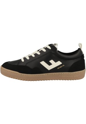 Black sneaker with leather and suede material, white laces, logo detail, beige rubber sole, and textured accents on the upper.
