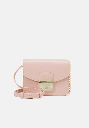 Petit sac bandoulière en cuir rose pastel avec une fermeture en métal doré et une sangle réglable, posé sur un fond blanc.