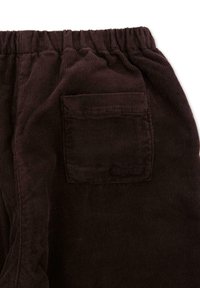 Pantalon en velours côtelé marron avec une surface texturée, une taille élastique et une poche arrière avec un logo discret.
