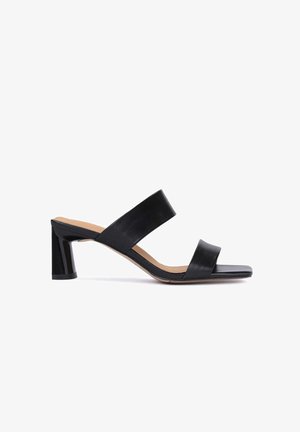 Sandale mule noire à bout ouvert avec deux larges brides et un talon bloc, vue de côté sur fond blanc.