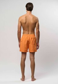 Oranžne kopalke iz lahkega materiala, z elastičnim pasom in zadnjim žepom. Hlače imajo preprost, brezšiven dizajn.