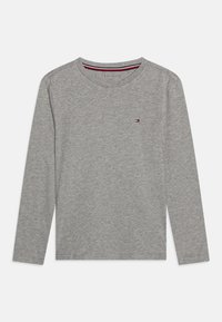 Grå långärmad T-shirt i mjuk bomull, med rund halsringning och en liten logotypdetalj på bröstet. Slät textur.