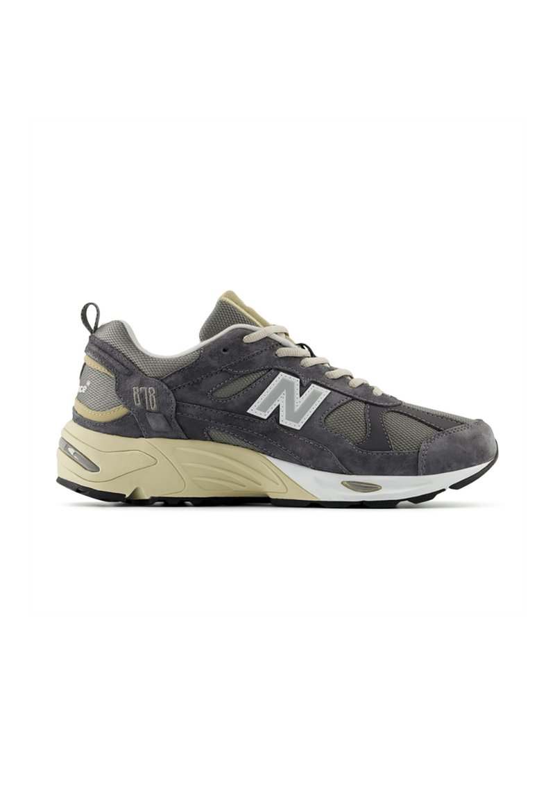 Scarpe sportive grigie e beige con materiali in suede e mesh, caratterizzate da una suola intermedia spessa, texture a contrasto e un prominente logo 'N'.