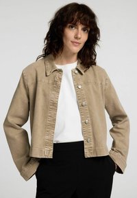 Beige denimjacka med krage,knäppning framtill och två framfickor. Designad med en kort längd och mjuk textur.