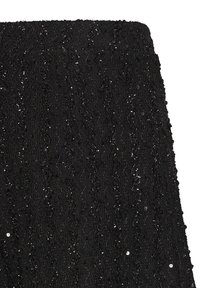 Jupe noire avec motif tricoté en zigzag texturé et petites paillettes dispersées pour briller.