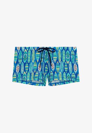 Un maillot de bain présentant un fond bleu avec des formes de feuilles colorées et décorées. Comprend un cordon de serrage noir à la taille.