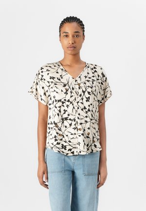 Kortermet bluse i krem med blomsterprøve i svart og gull, med V-hals og knappestolpe foran. Mykt stoff, avslappet passform.