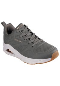 Zapatillas deportivas grises con parte superior de malla, diseño con cordones, perforaciones sutiles, suela acolchada y suela de goma marrón. Presenta la marca Skechers.