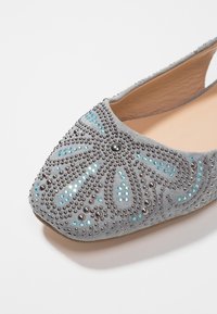 Ballerine in suede grigio con motivo floreale di perline e paillettes, punta affusolata e tallone aperto. Presenta perline metalliche e dettagli turchesi.