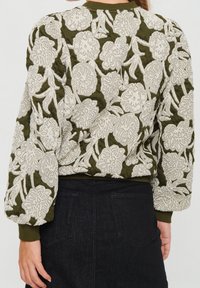 Olivgrüne Bomberjacke mit weißer floralem Stickerei, gerippten Bündchen und strukturiertem Stoff, mit voluminösen Ärmeln und verkürztem Saum.