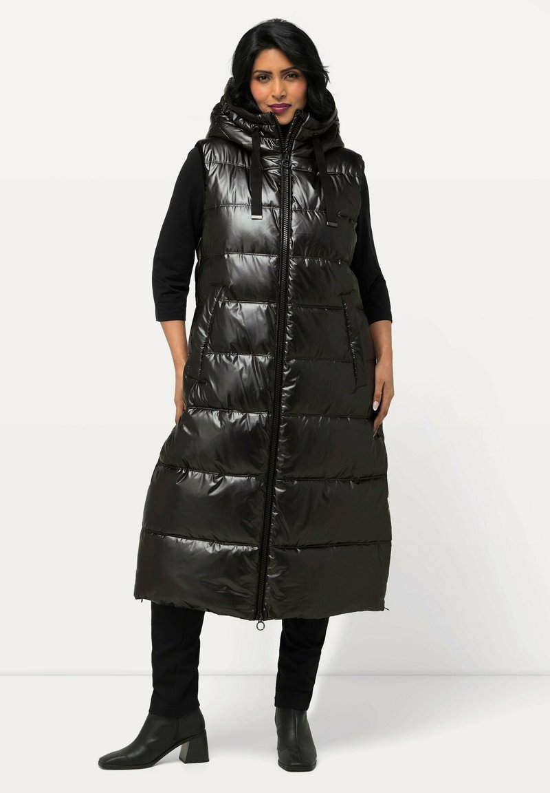 Schwarz glänzende lange Steppweste mit hohem Kragen und Kapuze. Verfügt über einen durchgehenden Reißverschluss, aufgesetzte Taschen und ein gestepptes Design.