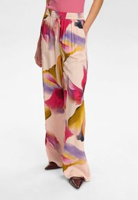 Pantaloni a gamba larga floreali in tessuto morbido e leggero, con una base rosa e motivi floreali viola, gialli e rossi, e una vita elastica.
