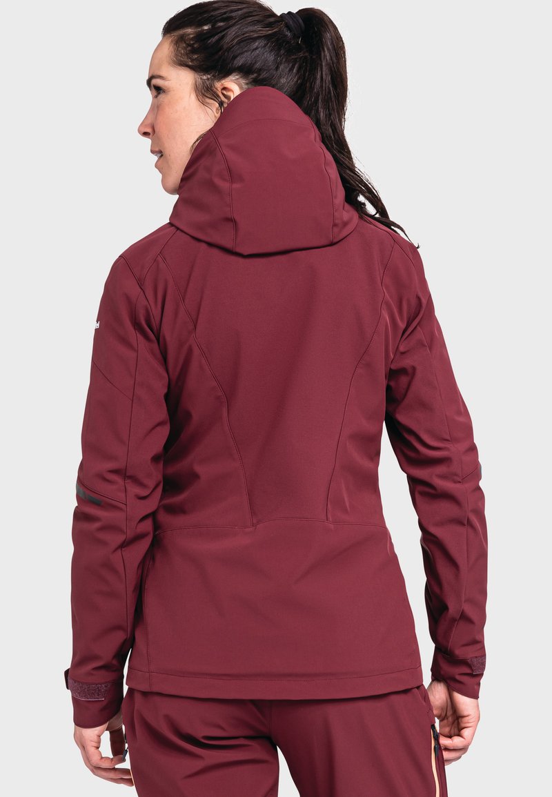 Burgunderfarbene Softshell-Jacke mit hochgeschlossenem Kragen, figurbetontem Design und Reißverschlussmanschetten. Sie verfügt über eine glatte Textur und subtile Nähdetails.
