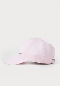 Rozā beisbola cepure, izgatavota no kokvilnas, ar izliekto malu, priekšā ar sudraba Nike logo un aizmugurē ar regulējamu siksnu.