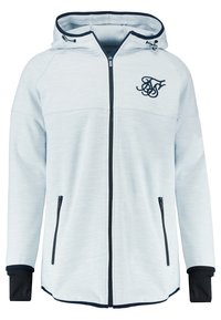 Veste à capuche gris clair zippée avec fermeture éclair noire et logo sur la poitrine, capuche ajustable avec cordons de serrage, et poignets intérieurs noirs sur les manches.