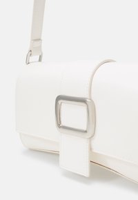 Borsa a tracolla bianca in pelle sintetica con forma rettangolare, accentuata da una fibbia in argento e una texture liscia. Dispone di una tracolla per un facile trasporto.