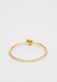 Kuldtooni bangle käevõru, millel on sile ja poleeritud viimistlus; sisaldab lihtsat sõlme detaili ja avatud klambri disaini mugavaks kandmiseks.