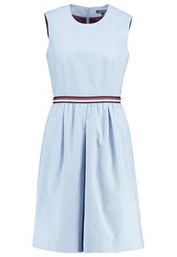 Robe bleu clair sans manches avec une finition texturée, corsage ajusté et jupe évasée. Comprend une ceinture rayée rouge et marine ainsi qu'une fermeture éclair à l'arrière.
