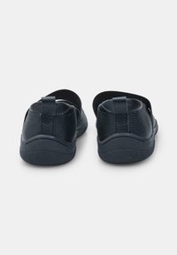 Czarne buty wsuwane z teksturowanej skóry, gumową podeszwą i elastycznymi paskami z tyłu ułatwiającymi zakładanie. Prosty i funkcjonalny design.