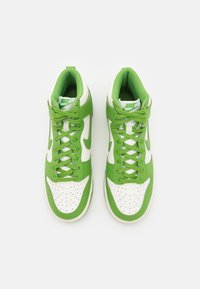 Gröna och vita högklackade sneakers med en texturerad mesh-tunga, perforerat tåskt och kontrasterande Nike-swoosh-logotyp.