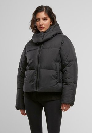 Giacca a vento nera con colletto alto, chiusura con zip e ampio motivo trapuntato. Presenta maniche larghe e un design cropped.