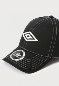 Μαύρο καπέλο μπέιζμπολ από ύφασμα, με λευκές ραφές και κεντημένο λογότυπο. Περιλαμβάνει έναν κυκλικό ρυθμιζόμενο ετικέτα μεγέθους στο χείλος.