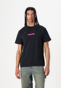 Black cotton t-shirt featuring a pink "FORMER" logo on the chest. The design is simple with short sleeves and a classic cut.