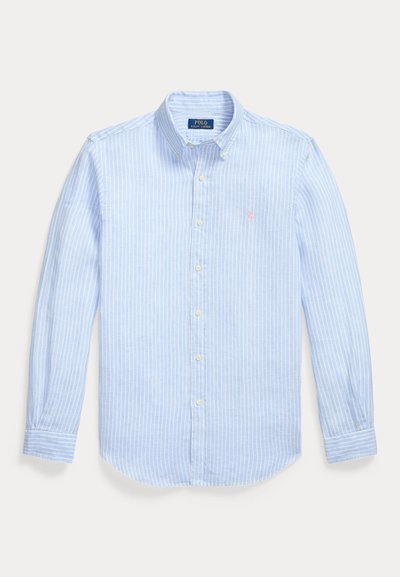 Helehall sinine triiksärk pikkade varrukatega, nööpidega, õhukeste valgete vertikaalsete triipudega ja väikese roosa tikitud logoga rinnal.