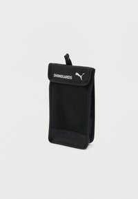 Συμπαγής μαύρος υφασμάτινος θήκη με καπάκι που φέρει την ένδειξη "SHINGUARDS" και το λογότυπο της Puma, σχεδιασμένη για αποθήκευση προστατευτικών κνήμης για αθλητισμό.