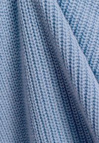 Tessuto a maglia azzurro chiaro con un motivo testurizzato, caratterizzato da diverse sfumature di blu. Il materiale sembra morbido e flessibile.