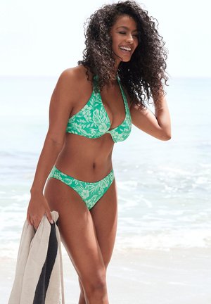 Set di bikini verde con design a collo halter e motivi floreali bianchi. Texture liscia con slip a copertura minima.