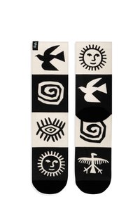 Sorte og hvide bomuldsstrømper med grafiske mønstre, herunder fugle, spiraler og en sol, der har en glat tekstur og kontrasterende farver.