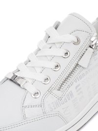 Sneaker in pelle bianca con lacci bianchi, occhielli argentati, una cerniera laterale e un testo stampato sottile sul lato esterno.