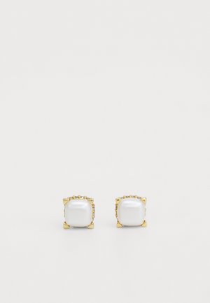 Zelta tonī auskari ar lielām, baltām, taisnstūrveida akmeņiem ar gludu tekstūru, apkārt kuriem ir mazi caurspīdīgi akcenti, veidoti četru stiprinājumu dizainā.