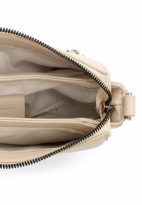Beige Lederhandtasche mit Reißverschluss, ausgestattet mit mehreren Innenfächern und einer strukturierten Oberfläche. Innenfutter aus hellem Stoff.