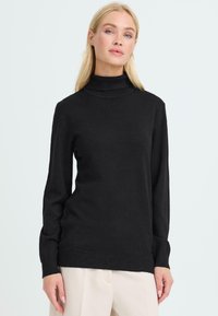 Schwarzer Rollkragenpullover aus weichem Strickmaterial mit langen Ärmeln und gerippten Bündchen, der ein minimalistisches Design und eine lässige Passform aufweist.