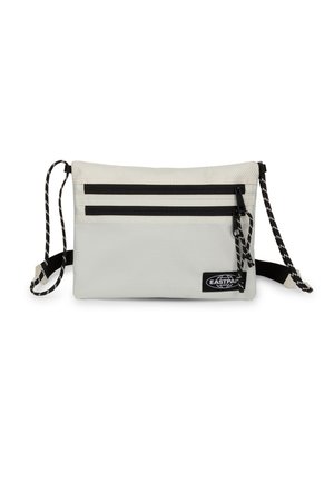 Lille rektangulær lysegrå crossbody-taske med to sorte lynlåslommer og en sort-hvid justerbar rem.