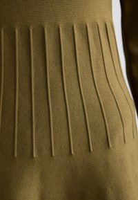 Tessuto a maglia verde oliva con motivo a righe verticali. Presenta sezioni alternate lisce e in rilievo per un aspetto tattile.