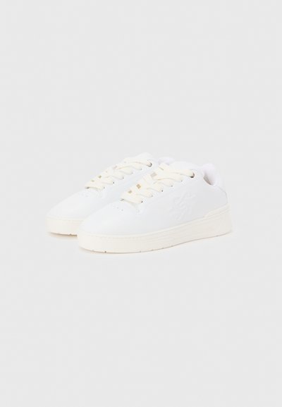 Λευκά αθλητικά παπούτσια με λείο συνθετικό επάνω μέρος, στρογγυλεμένη μύτη και κορδόνια στο ίδιο χρώμα. Διαθέτουν διακριτικό λογότυπο και υφή στην καουτσούκ σόλα.