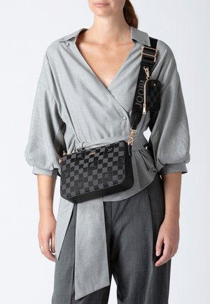 Schwarz karierte Umhängetasche mit goldenen Beschlägen, ausgestattet mit einem abnehmbaren Mini-Pouch. Das Material hat eine glatte Textur und ein strukturiertes Design.