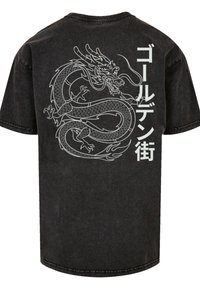 Black cotton t-shirt featuring a white dragon graphic and text in Japanese characters on the back. Short sleeves and a relaxed fit.