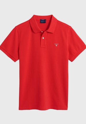 Rotes Polohemd mit kurzen Ärmeln, zwei Knöpfen, Kragen und kleinem GANT-Logo auf der linken Brust.