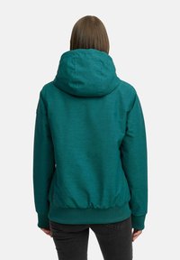 Teal hettegenser med stor krage og elastisk midjebånd, laget av et teksturert stoff. Har lange ermer og et logopatch ved nederkanten.